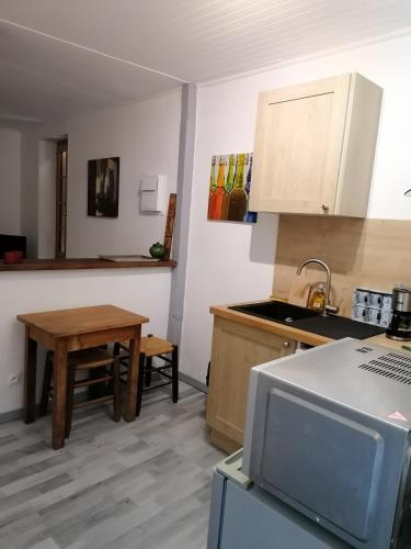 a kitchen with a table and a sink and a stove at En Provence à MOLLANS in Mollans-sur-Ouvèze