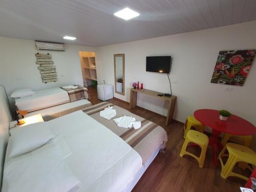 a bedroom with a bed and a table and chairs at Pousada Igrejinha dos Carneiros in Tamandaré