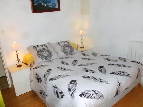 プルガヌーにあるMaison de charme à Plougasnou avec jardin clôturéのベッドルーム1室(ベッド1台、白黒の掛け布団付)
