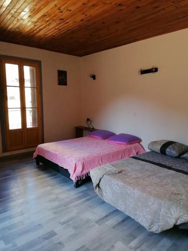 a bedroom with two beds and a wooden ceiling at En Provence à MOLLANS in Mollans-sur-Ouvèze