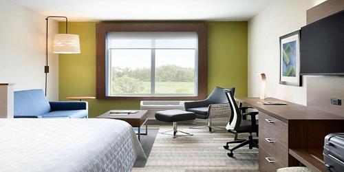 Pokój hotelowy z łóżkiem, biurkiem i krzesłami w obiekcie Holiday Inn Express & Suites - Lumberton, an IHG Hotel w mieście Lumberton