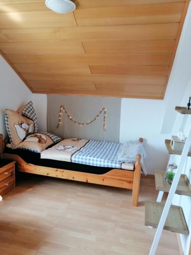 Bett in einem Zimmer mit Holzdecke in der Unterkunft Familie Barth in Kleinmürbisch