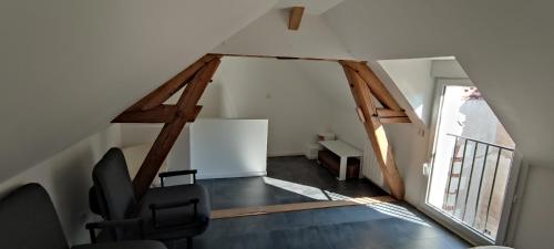 a room with a chair and a desk in a attic at Noyers Val de Cher in Noyers-sur-Cher