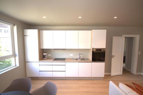 a kitchen with white cabinets and a sink at Odda Apartments in Odda