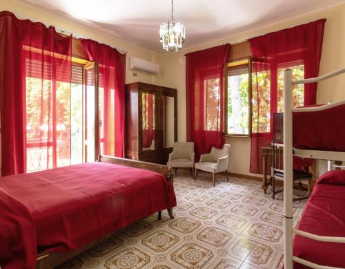 una camera da letto con tende rosse e un letto e sedie di Villa Nicodemo a Paestum