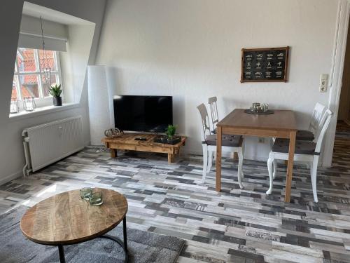 uma sala de estar com uma mesa e uma televisão em Piratenkoje em Flensburg