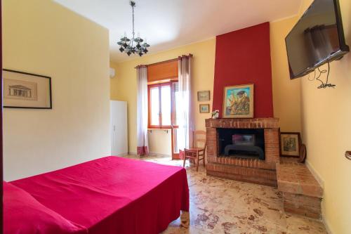 a bedroom with a red bed and a fireplace at Villa Nicodemo in Paestum