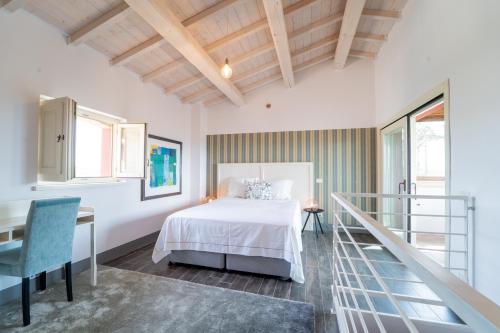 Habitación blanca con cama, escritorio y ventanas en Agriturismo Il Sarale - Umbria, en Città di Castello