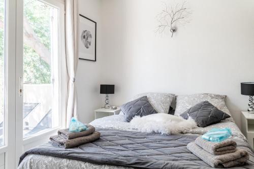 - un lit avec serviettes dans une chambre avec fenêtre dans l'établissement Le Petit Thao, à Fréjus