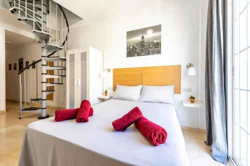- une chambre avec un lit blanc et des oreillers rouges dans l'établissement Private Rooftop & Elegant studio - Center by REMS, à Malaga