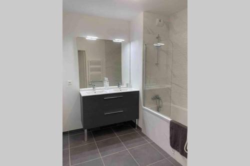 uma casa de banho com um lavatório, um espelho e uma banheira em New appartement with 2 bedrooms in a new building em Cagnes-sur-Mer