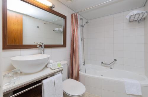 La salle de bains est pourvue d'un lavabo, de toilettes et d'une baignoire. dans l'établissement Prima Royale Hotel, à Jérusalem