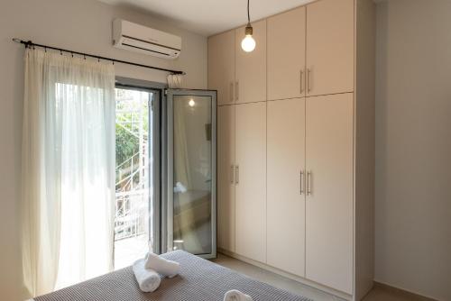 a bedroom with a bed and a glass door at Garden House Preveza in Preveza