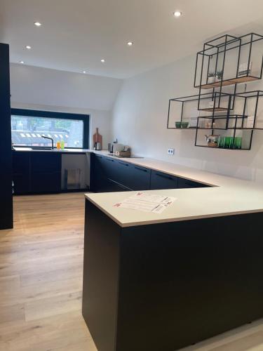 a kitchen with a black and white counter top at NEOZONE Appart-Hotel Malmedy in Malmedy