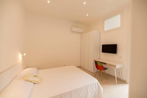 a white bedroom with a bed and a desk at Marina Grande Holiday Apartment in Capri in Capri
