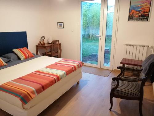 1 dormitorio con 1 cama y puerta corredera de cristal en Chèvrefeuille gîte & chambre d'hôtes, en Moltig les Bains