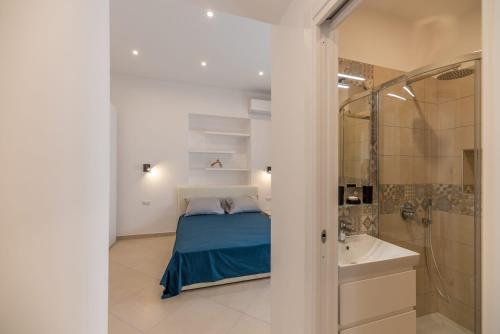 a bedroom with a bed and a shower and a sink at Marina Grande Holiday Apartment in Capri in Capri