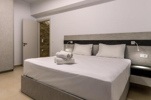 Un dormitorio con una gran cama blanca con una bolsa. en Achlia Beach Villa 2, en Achlia