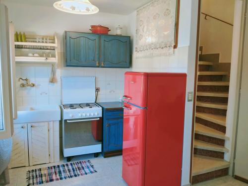 a kitchen with a red refrigerator and blue cabinets at CalmasinoRooms in Calmasino