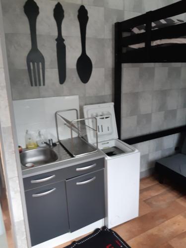 a kitchen with a sink and utensils on the wall at MAISON Studio SEDAN Meublé 14M2 INDEPENDANT in Sedan