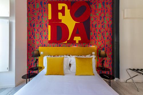a bedroom with a bed with yellow pillows and a red wall at Portas do Céu Apartments in Lisbon