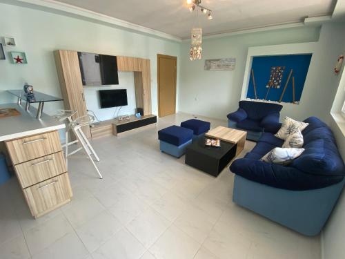 a living room with a blue couch and a kitchen at Blue Lagoon apartment next to the centre Kranevo. in Kranevo