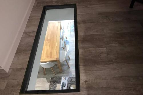 un miroir reflétant une table et des chaises dans la chambre dans l'établissement Plein cœur Cauterets: Appartement 6/8 personnes, à Cauterets