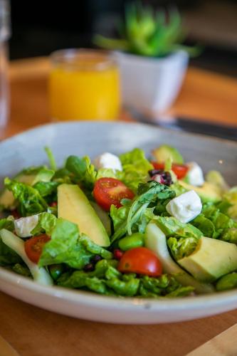 a salad on a white plate on a table at Best Western London Heathrow Ariel Hotel in Hillingdon