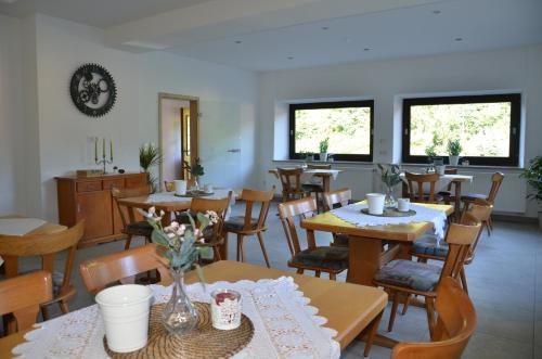 a dining room with tables and chairs and windows at Ferienhaus Tüchersfeld in Pottenstein