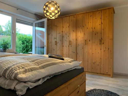 a bedroom with a bed with a wooden wall at Ferienwohnung Das Inge De Unterne in Bernau am Chiemsee