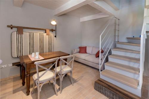 a dining room with a table and a stairway at I Casali di Villa Benveduti in Gubbio