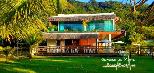 a house with chairs and tables in front of it at Bella Gamboa Casa de Praia - Gamboa, Morro de São Paulo - in Gamboa