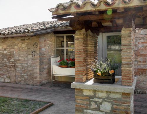 a brick building with a window with flowers on it at I Casali di Villa Benveduti in Gubbio