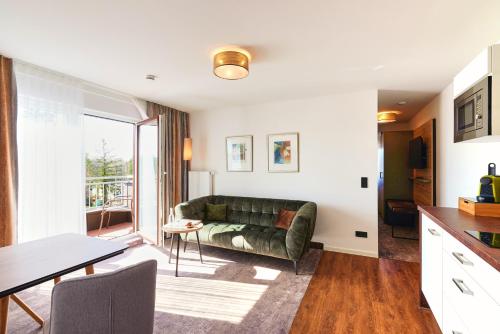 a living room with a couch and a table at Hotel SCHNEIDER in Allersberg