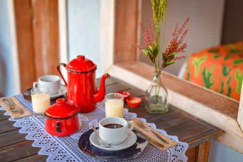 a table with two cups of coffee and candles on it at EcoCharme Pousada Netuno in Fernando de Noronha