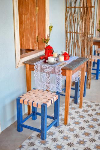 a table with a chair and a table with tea pots on it at EcoCharme Pousada Netuno in Fernando de Noronha