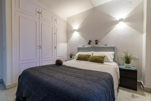 a bedroom with a large bed with two green pillows at MalagaSuite Soho apartment in Málaga
