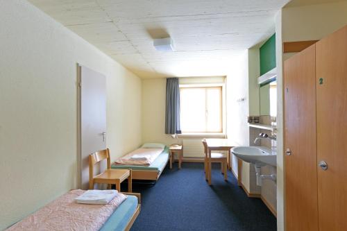 a hospital room with two beds and a sink at St. Moritz Youth Hostel in St. Moritz