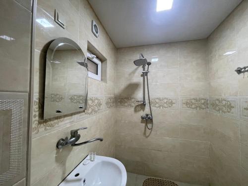 een badkamer met een wastafel en een douche bij Fazis Hotel in Poti
