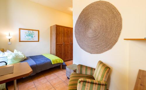 a hotel room with a bed and a chair at Appartementhaus Witzmann in Bad Vöslau