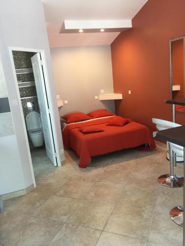 - une chambre avec un lit rouge et une salle de bains dans l'établissement Dépendance individuelle, à Nans-les-Pins