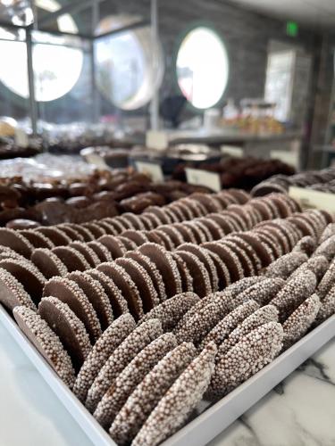 a row of chocolate donuts on a shelf in a bakery at Comfort Suites Chincoteague Island Bayfront Resort in Chincoteague