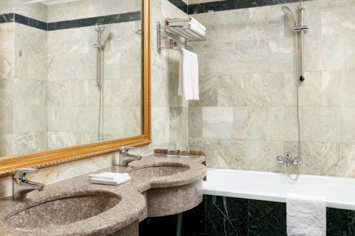 two sinks in a bathroom with a mirror and a shower at Hotel Lime Krasnoselskaya in Moscow