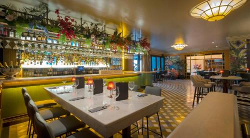 un restaurante con mesas y sillas y un bar en The Victoria Hotel en Galway
