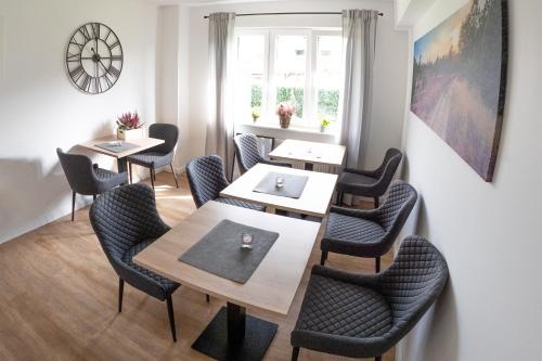 a dining room with tables and chairs and a window at lütte Heidepension in Schneverdingen