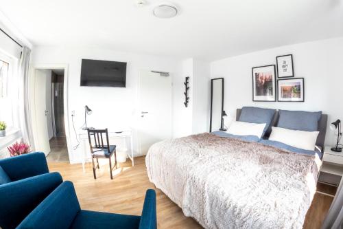 1 dormitorio con cama, silla y escritorio en lütte Heidepension en Schneverdingen