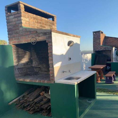 a outdoor kitchen with a brick oven on a patio at Hotel Buena Vista Se reserva solo con seña in San Gregorio de Polanco