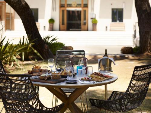 a table with plates of food and wine glasses at Domotel Kastri in Athens