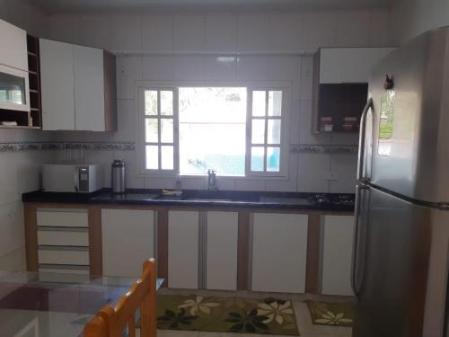 eine Küche mit Spüle und Kühlschrank in der Unterkunft Casa Ampla e Confortável a 10 minutos Praia Ubatumirim Cambuca in Ubatuba