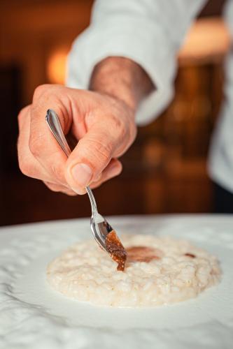 a person is eating food on a plate with a spoon at Grand Hotel San Pietro Taormina in Taormina